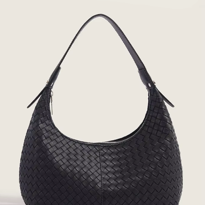 Classic black woven vegan leather mini tote side profile showing curved silhouette