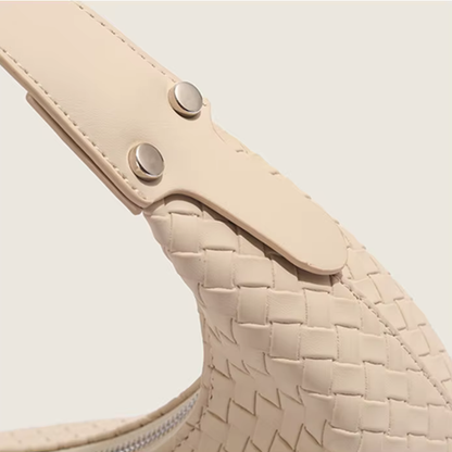 Close-up of adjustable strap hardware and woven leather texture in soft ivory
