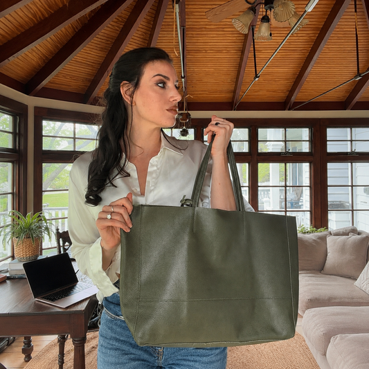 The Isla oversized leather shopper tote in Olive Green, held by the handles