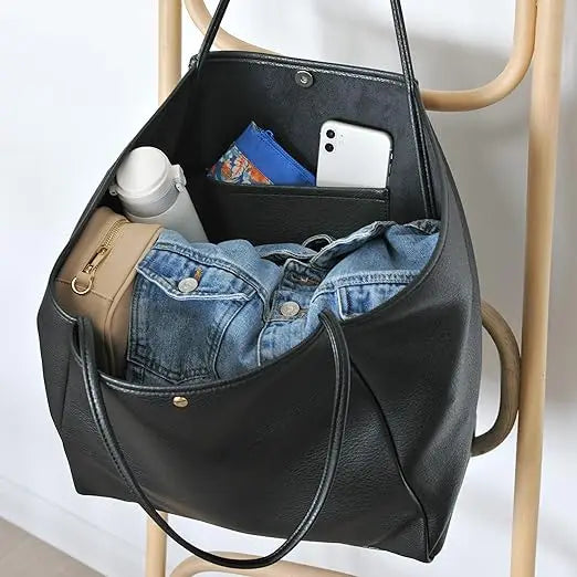 The Juno tote interior holding a denim jacket, water bottle, phone and wallet